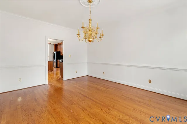 a view of a room with wooden floor and chandelier