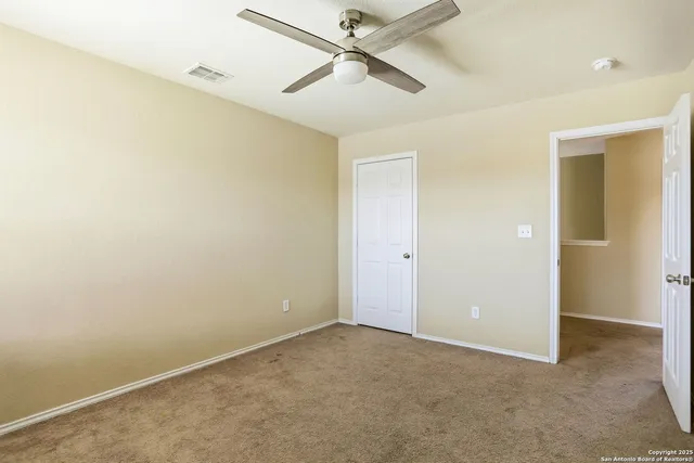 an empty room with a window and a fan
