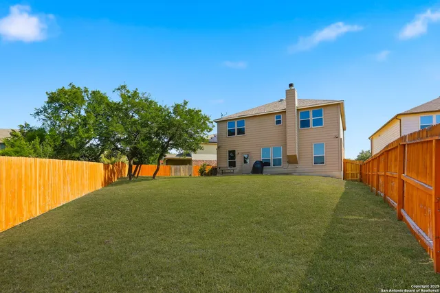 a front view of house with yard and trees in the background