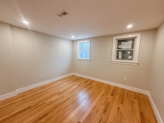 a view of empty room with wooden floor