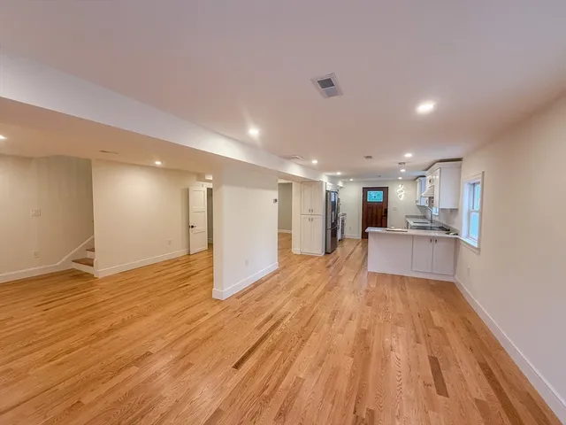 a view of a kitchen with kitchen island wooden floor center island and windows