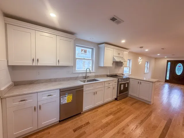 a kitchen with a white wooden cabinets and stove top oven