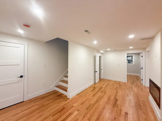 an empty room with wooden floor and white walls