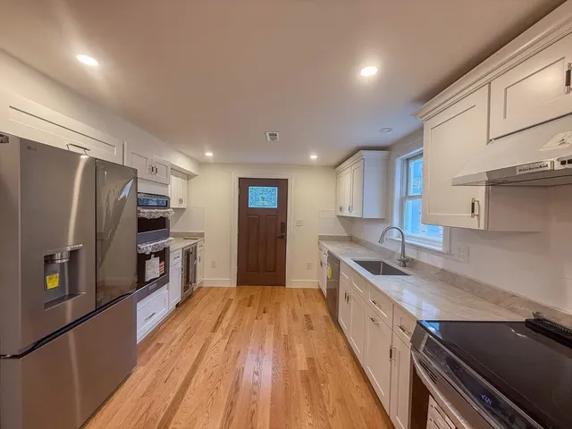 a large kitchen with a large counter top stainless steel appliances and cabinets