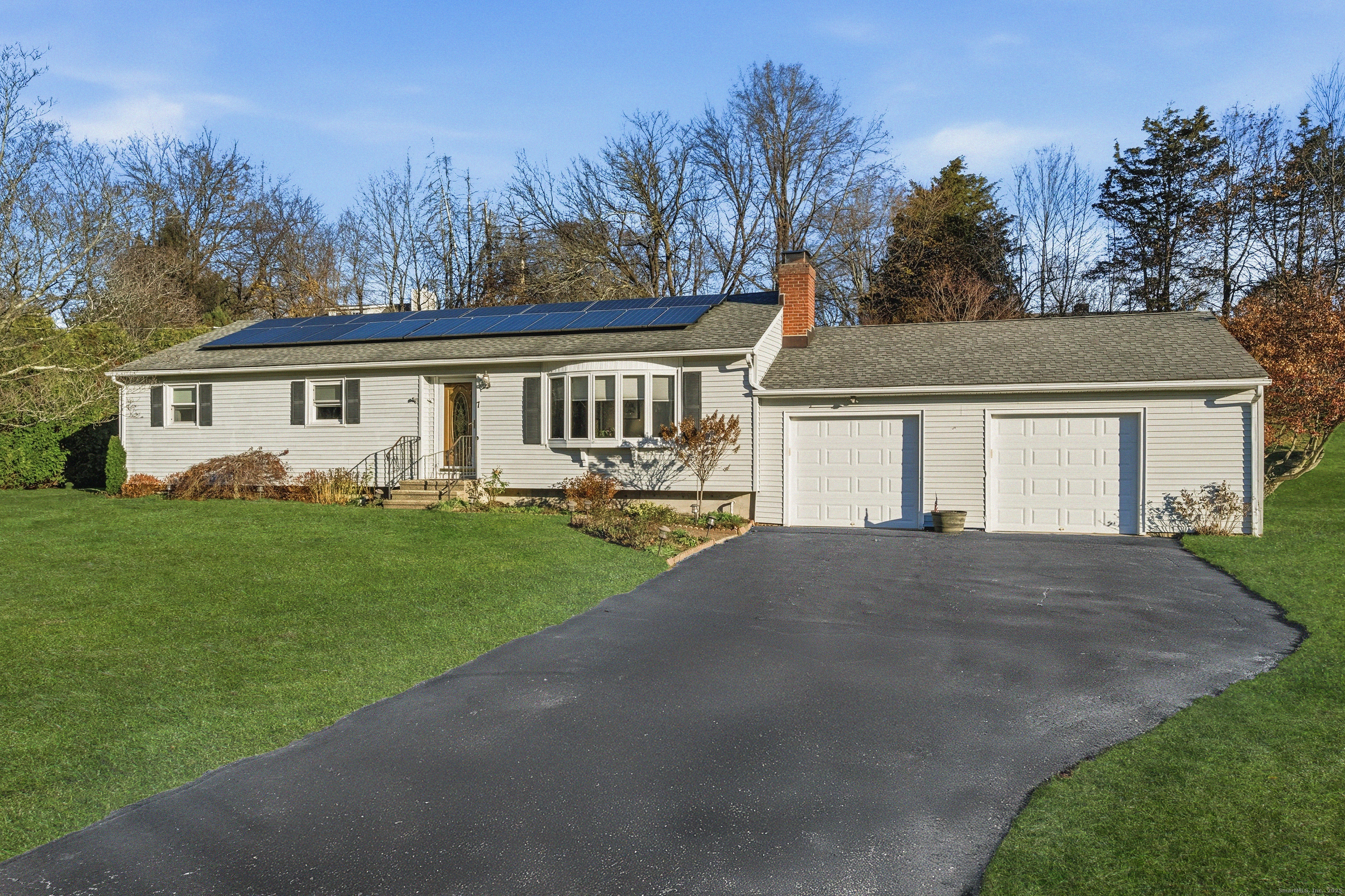a front view of a house with a yard and trees