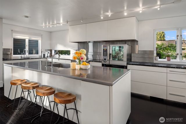 a kitchen with stainless steel appliances a sink and a large window