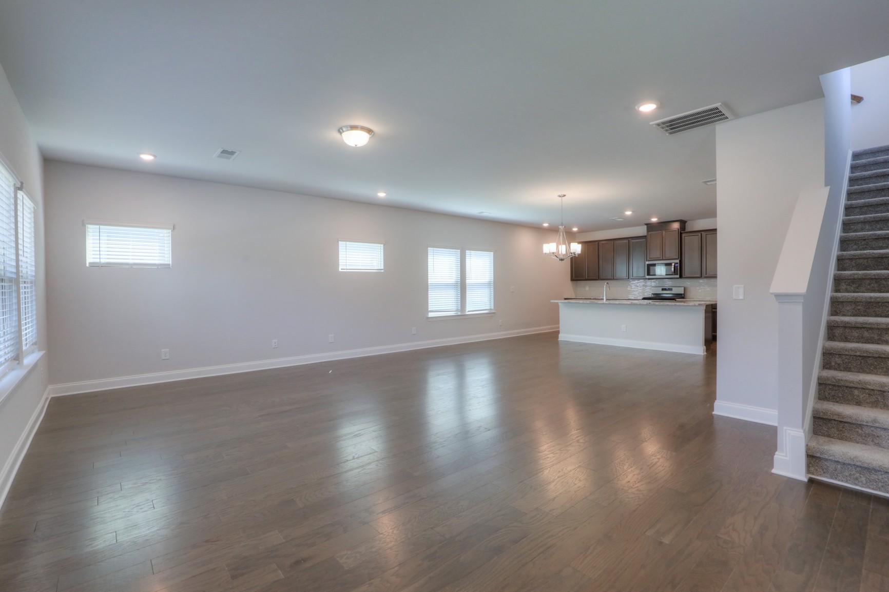 3546 Four Leaf Way Antioch, TN 37013 - Photo 6 of 35 an empty room with wooden floor and a kitchen