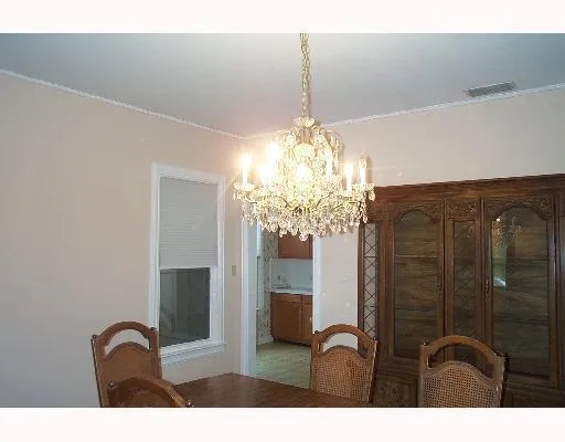 a bathroom with a granite countertop sink a light fixture and a glass door