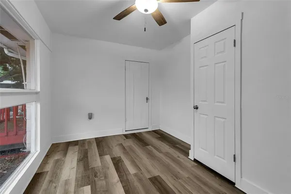 a view of an empty room and chandelier fan