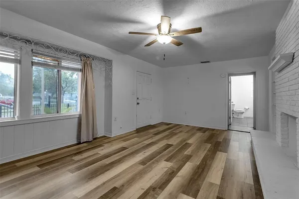 a view of a livingroom with a chandelier fan and windows