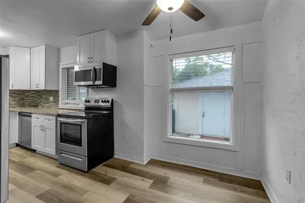 a kitchen with stainless steel appliances granite countertop a stove top oven a sink and a microwave