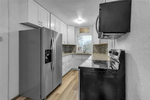 a kitchen with stainless steel appliances granite countertop a refrigerator and a stove