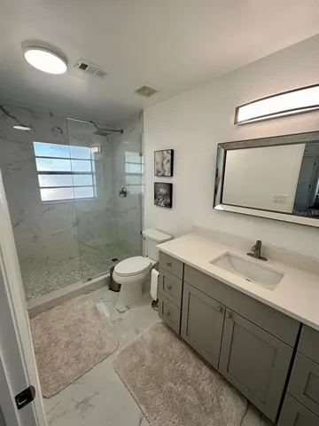 a spacious bathroom with a toilet sink and mirror