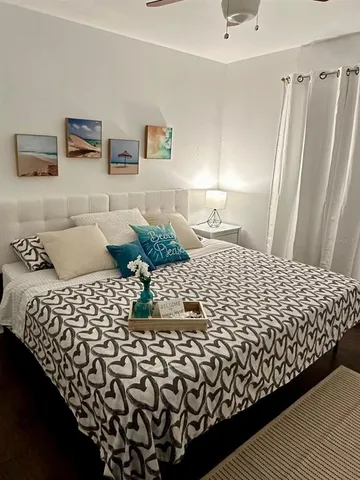 a large bed sitting in a bedroom next to a window and a lamp