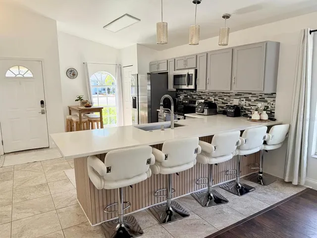 a kitchen with a sink a counter and chairs