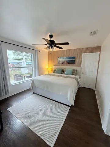 a bedroom with a bed and wooden floor