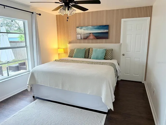 a bedroom with a bed wooden floor and window