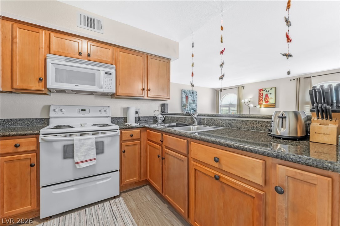 3145 East Flamingo Road, Unit 1092 Las Vegas, NV 89121 - Photo 9 of 33 A well-appointed kitchen features ample counter space and natural wood cabinetry, ideal for culinary endeavors.
