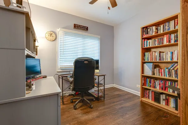 a view of a workspace with furniture and a book shelf