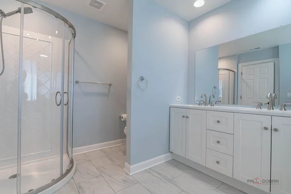 a spacious bathroom with a double vanity sink mirror and shower