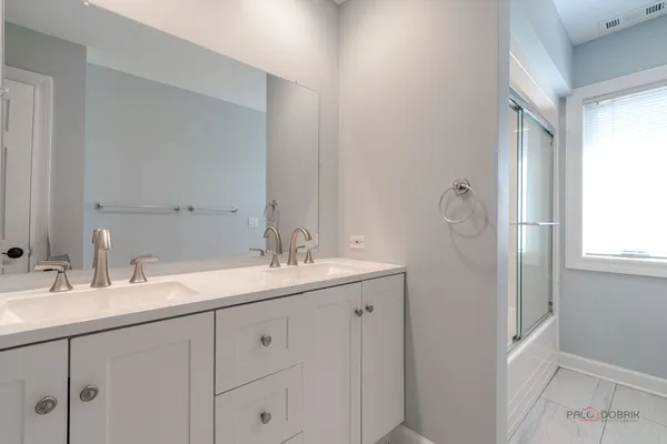 a bathroom with a double vanity sink and mirror