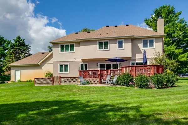 a front view of a house with a yard and green space