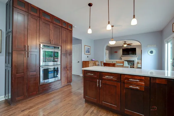 a kitchen with stainless steel appliances a stove a refrigerator and a wooden floor