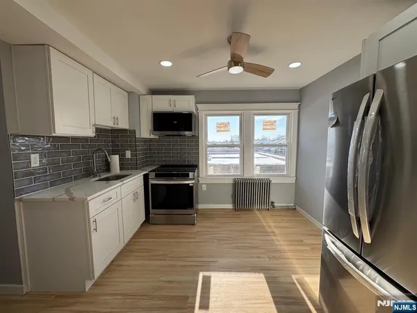 a kitchen with granite countertop a refrigerator stove and sink
