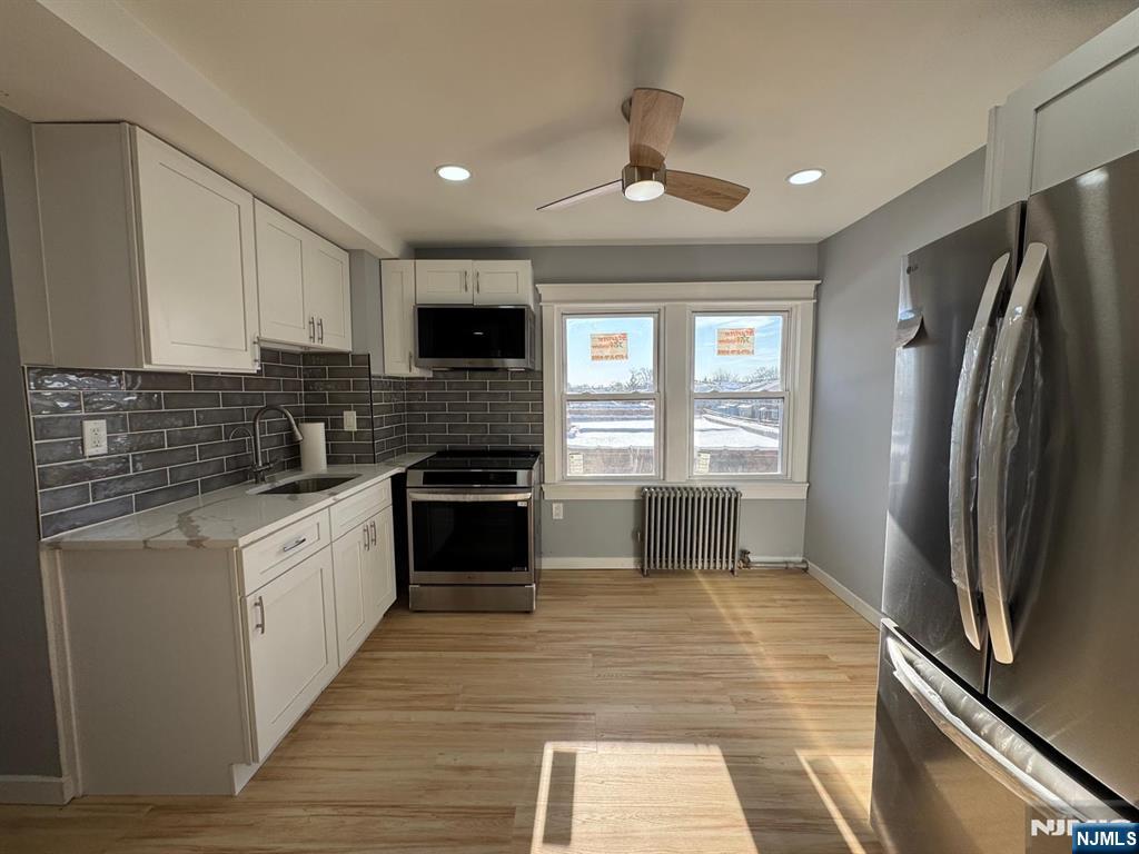 166 Rutherford Place, Unit 2 North Arlington, NJ 07031 - Photo 3 of 10 a kitchen with granite countertop a refrigerator stove and sink