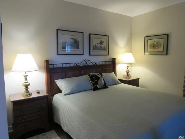 a bedroom with a bed and a lamp on dresser