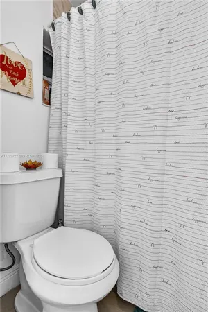 a white toilet sitting next to a white wall