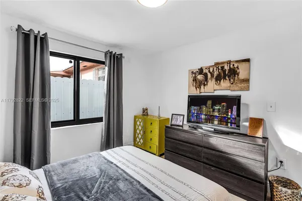 a bedroom with a bed and large windows