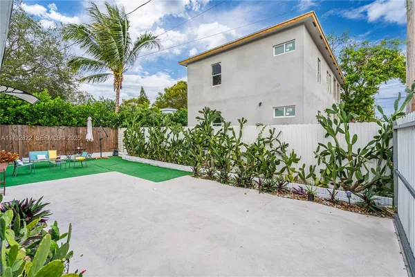 a view of backyard with potted plants and a large tree