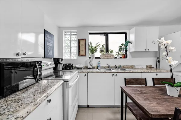 a kitchen with a stove a sink a dining table and chairs