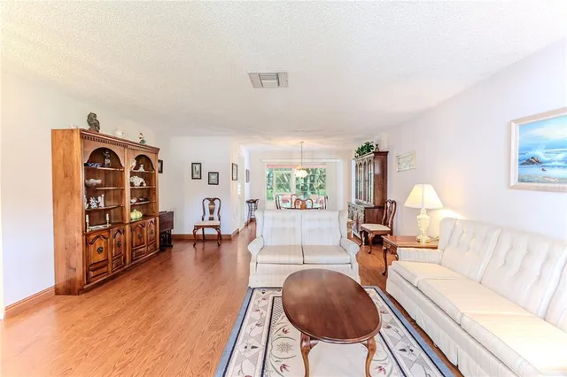 a view of a dining room with furniture a chandelier and wooden floor