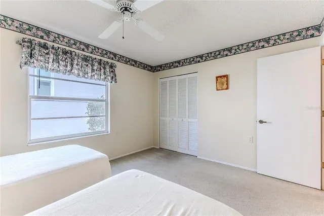 a view of a white house with a big yard and potted plants