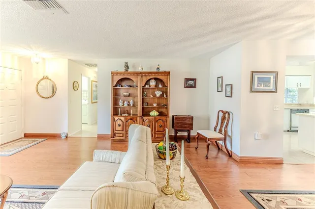 a living room with furniture a rug and a floor to ceiling window