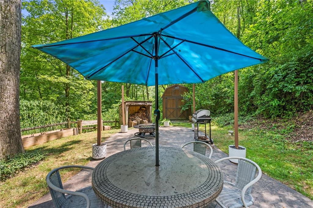 210 Arner Road Freeport, PA 16229 - Photo 29 of 40 a patio with a table and chairs under an umbrella