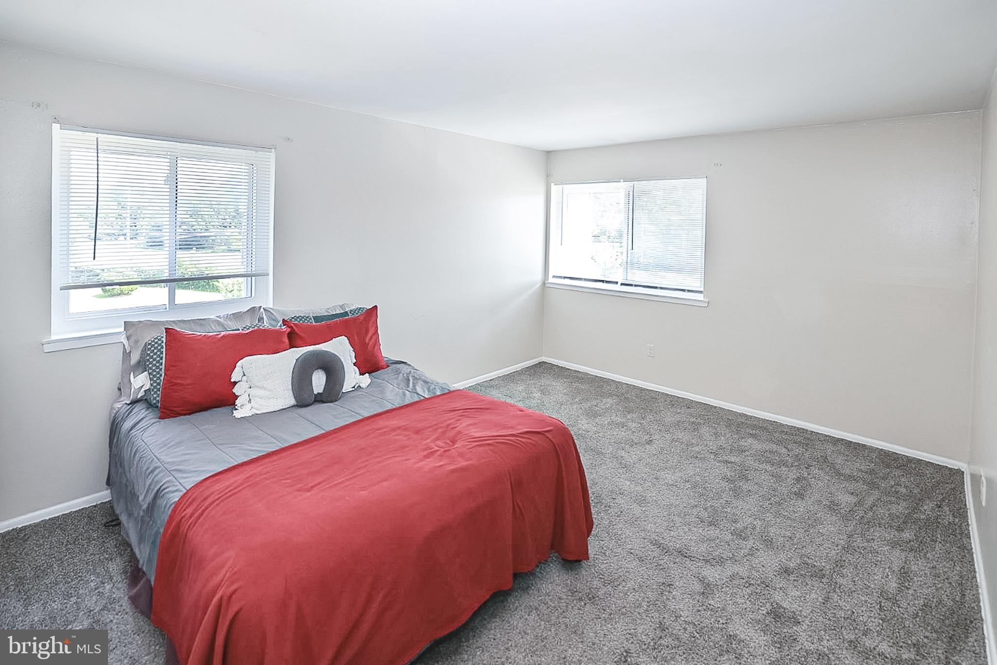 10214 Prince Place, Unit 8202 Upper Marlboro, MD 20774 - Photo 17 of 22 a bed sitting in a bedroom next to a window