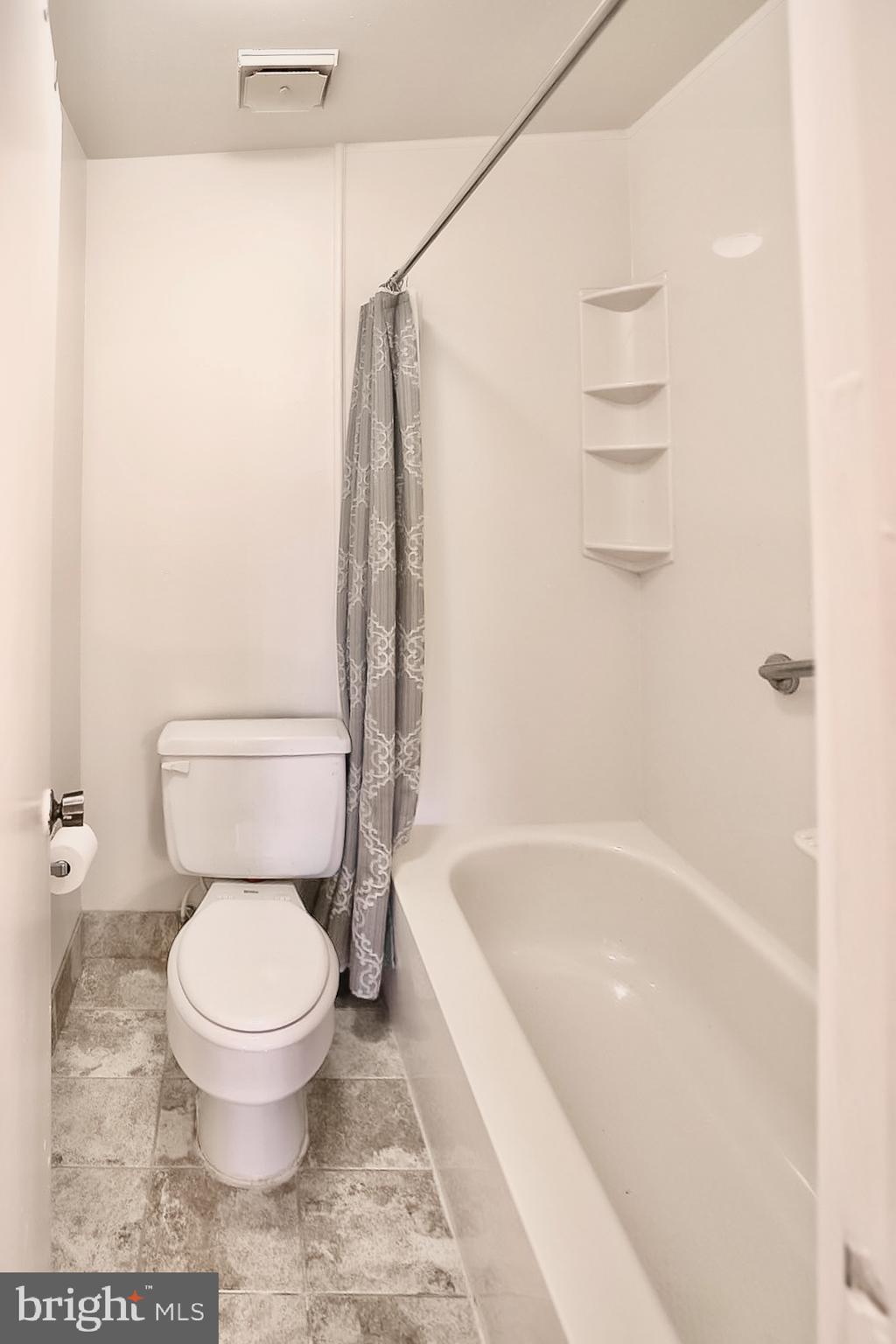 10214 Prince Place, Unit 8202 Upper Marlboro, MD 20774 - Photo 18 of 22 a white toilet sitting next to a bath tub and a shower