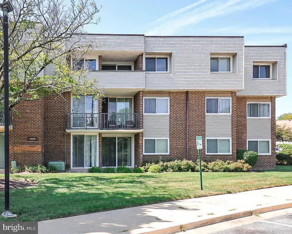 front view of a brick house next to a yard