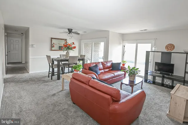 a living room with furniture a flat screen tv and a dining table