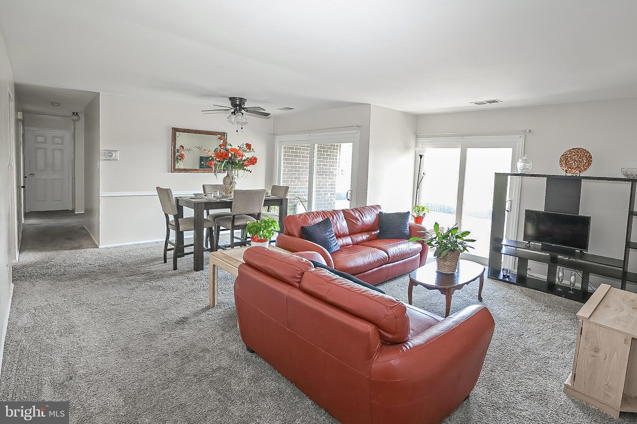 10214 Prince Place, Unit 8202 Upper Marlboro, MD 20774 - Photo 5 of 22 a living room with furniture a flat screen tv and a dining table