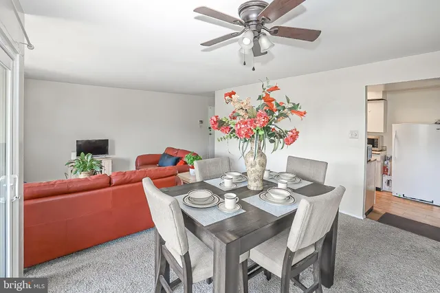 a dining room with furniture a potted plant a chandelier and a window