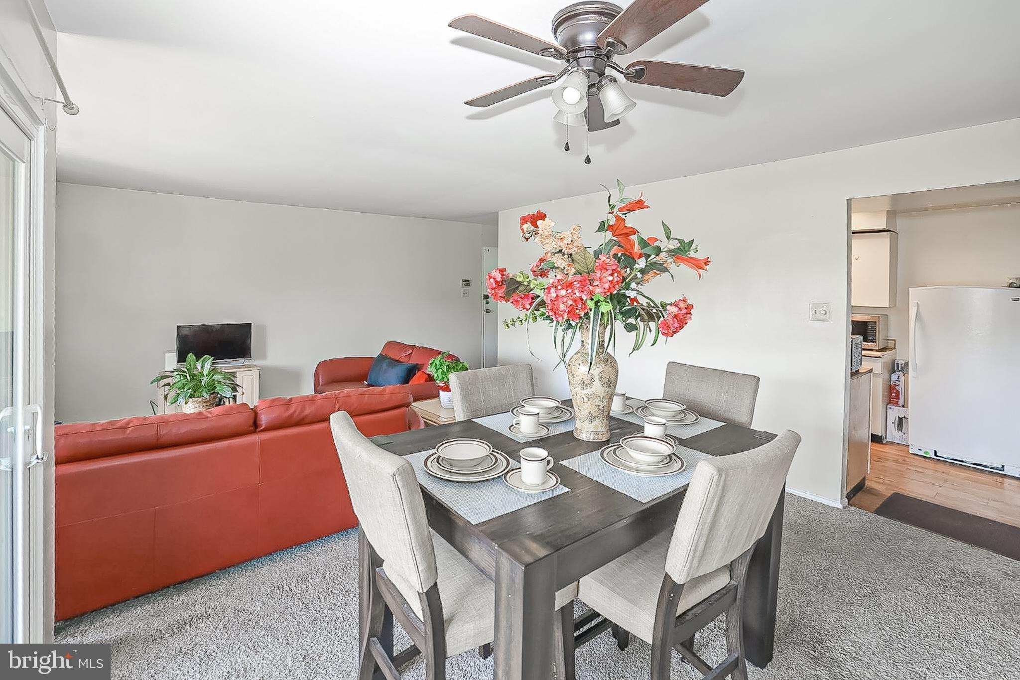 10214 Prince Place, Unit 8202 Upper Marlboro, MD 20774 - Photo 6 of 22 a dining room with furniture a potted plant a chandelier and a window