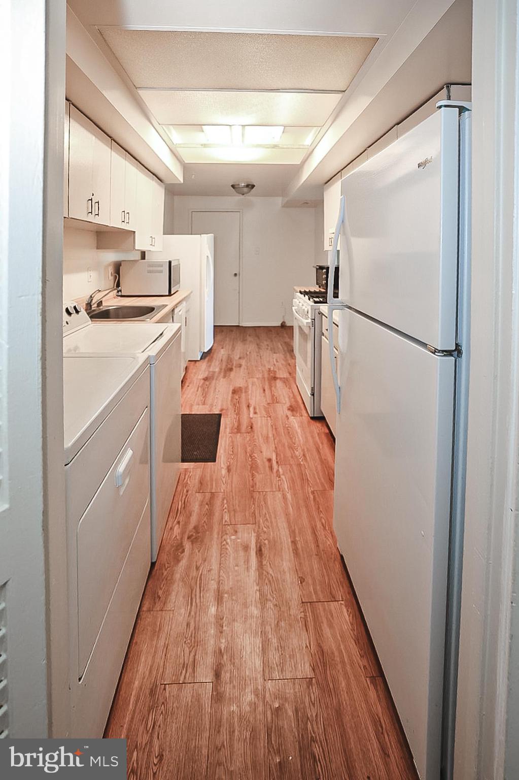 10214 Prince Place, Unit 8202 Upper Marlboro, MD 20774 - Photo 7 of 22 a kitchen with white cabinets and stainless steel appliances