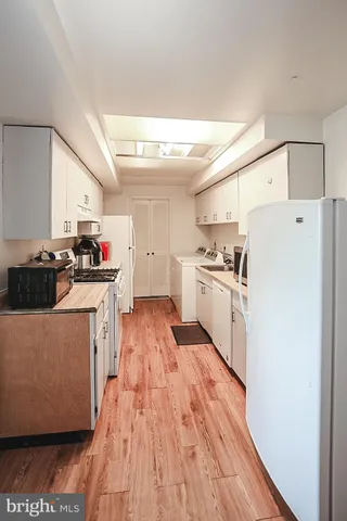 a kitchen with wooden floor and white appliances
