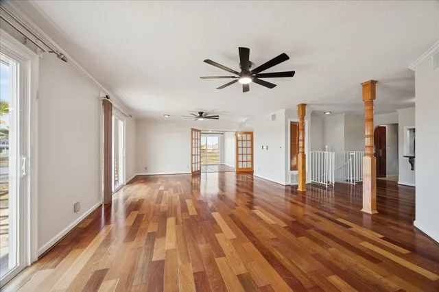 a view of a livingroom with wooden floor and a ceiling fan