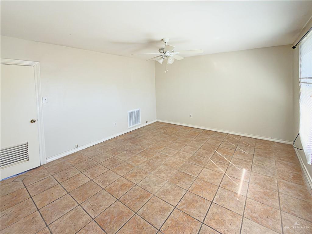 706 West 10th Street Weslaco, TX 78596 - Photo 5 of 14 an empty room with a chandelier fan