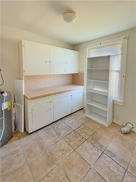 706 West 10th Street Weslaco, TX 78596 - Photo 9 of 14 a utility room with cabinets washer and dryer